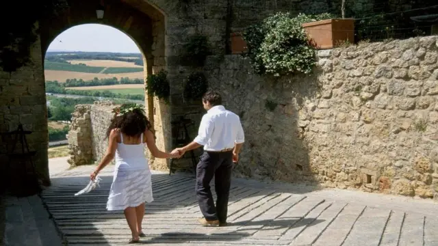 Una pareja caminando por una calle en un pueblo italiano