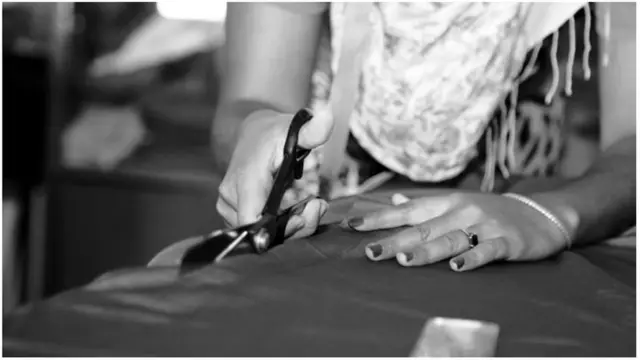 Msichana akikata kitambaa na mkasi