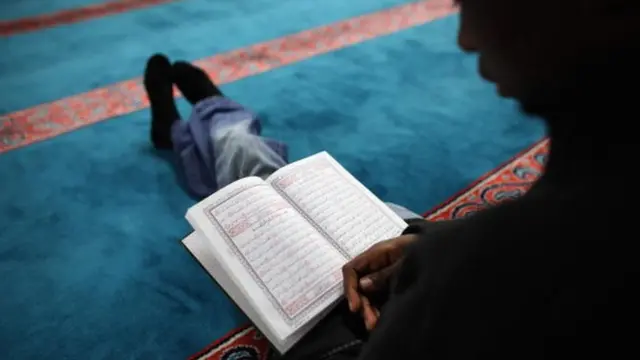 A Muslim man reads the Koran before Iftar
