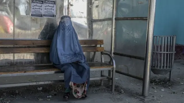 কাবুলের বাস স্টপে অপেক্ষমান নারী।