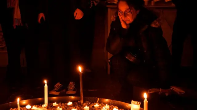 سيدة حزينة أمام شموع مشتعلة