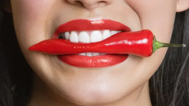 Acı biber ısıran kadın