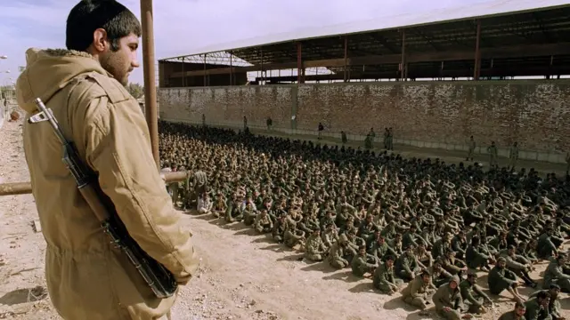 আহবাজ বন্দী শিবিরে ইরাকি যুদ্ধবন্দীদের ওপর নজর রাখছে ইরানের একজন সৈন্য, ২২ জানুয়ারি, ১৯৮৭