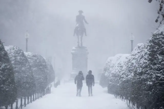 Boston'da George Washington heykeli önünde kar fırtınasında yürüyenler