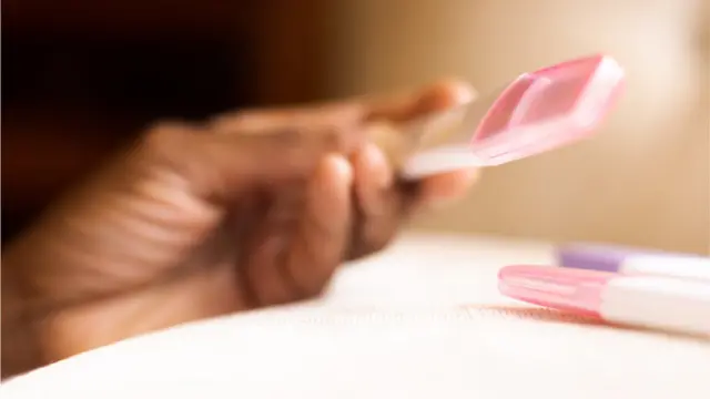 Una mujer con una prueba de embarazo