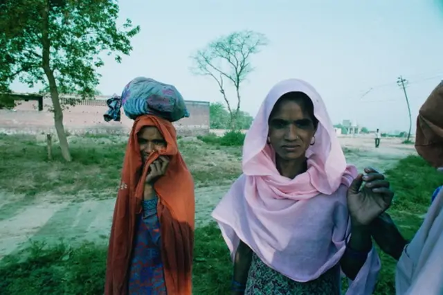 Duas mulheres Dalit com trajes típicosjogo dinheiro de verdadeterreno aparentemente baldio