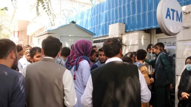 Afghans gather outside a closed bank in Kabul, Afghanistan, 25 August 2021