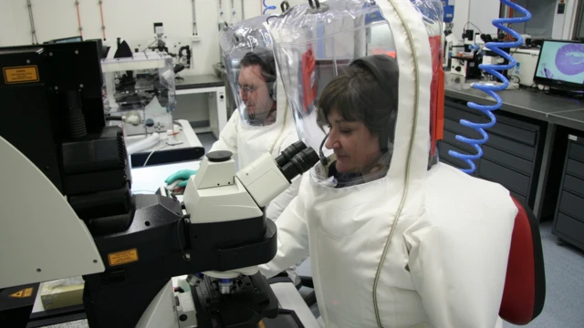 Ученые в защитных костюмах