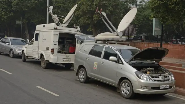 TV satellite vans parked in street in Delhi