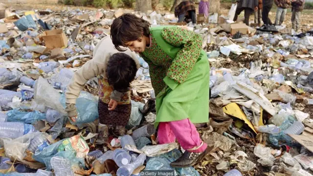 कूड़े में खाने की तलाश करते हुए बच्चे