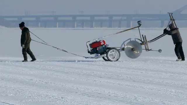 শ্রমিকরা বরফ বৈদ্যুতিক করাত দিয়ে বরফ কেটে তৈরি করেন বিভিন্ন ভবন ও ভাস্কর্য