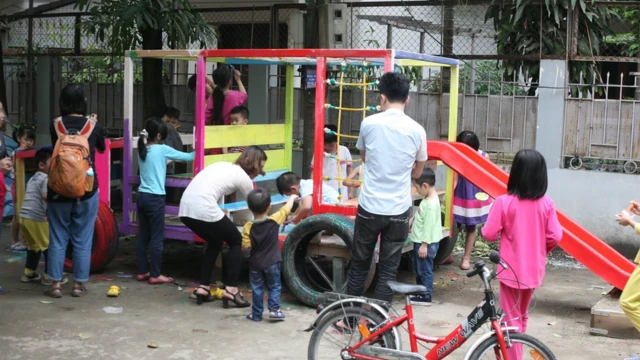Children in Hanoi paint their new climbing frame.