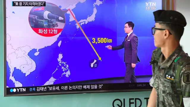 Ведущий корейского телевидения показывает остров Гуам на карте