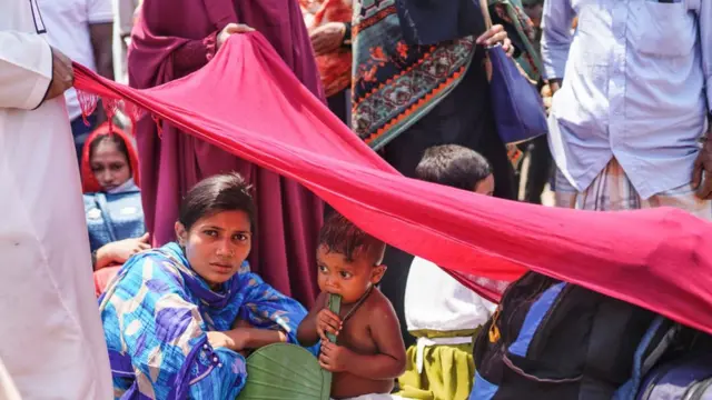 মুন্সিগঞ্জের ঘাটে এক নারী ও শিশু গ্রামের বাড়ি যাবার জন্য অপেক্ষা করছেন, ১০/০৫/২০২১