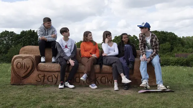 Da esquerda para a direita: Ben, Jacob, a repórter Marianna, Poppy, Izzy e Patrick, no banco memorial a Olly