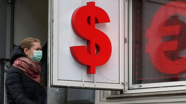 Mujer con tapabocas frente a los signos de peso y euro.