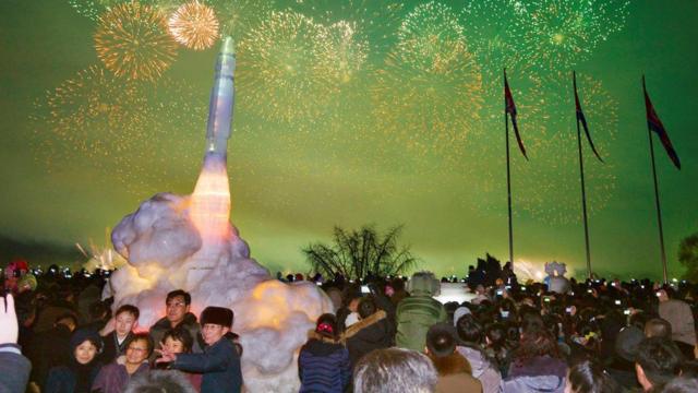 平壤民众在新年的焰火下与洲际弹道导弹冰雕合影