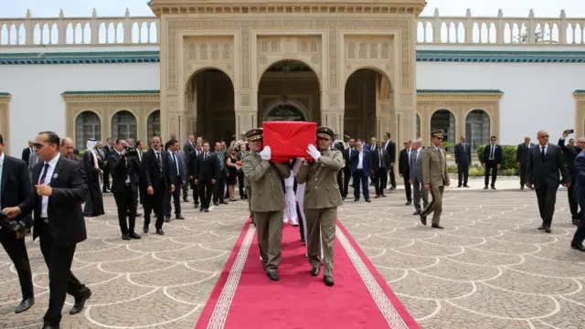 ضباط يحملون جثمان السبسي.