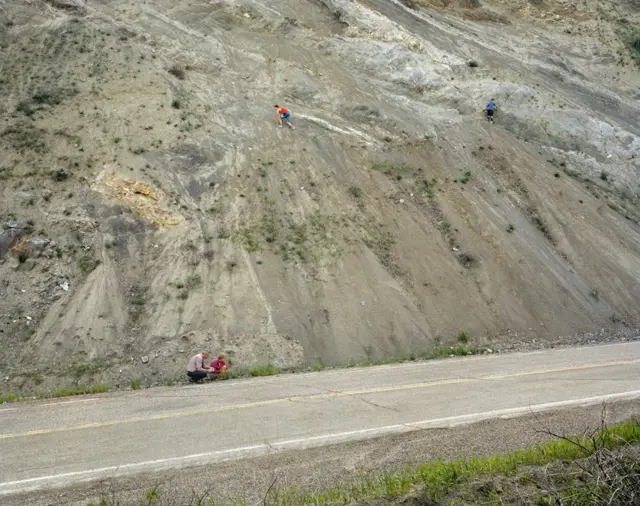 Children climbing a roadside embankment