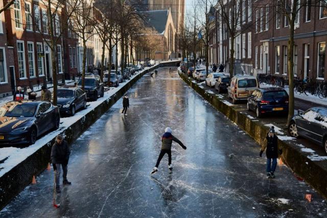 أشخاص يتزلجون على الجليد في هولندا بعد تجمد القنوات والبحيرات والأنهار