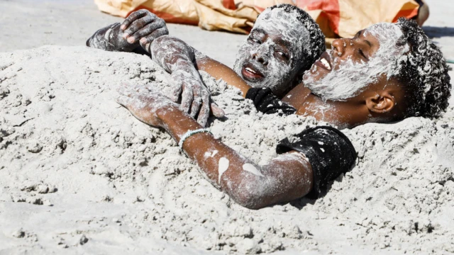 Des garçons somaliens se couvrent de sable sur la plage du Lido à Mogadiscio, Somalie - Vendredi 28 janvier 2022