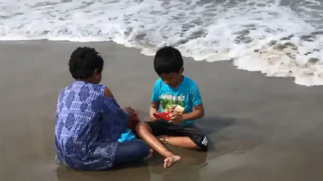 সৈকতে খেলা করছে দুটি শিশু