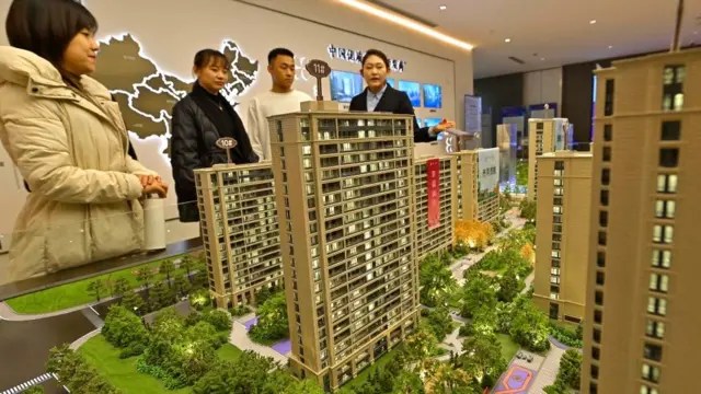 চীনে ক্রেতাদের সামনে নতুন তৈরি বাড়ির মডেল তুলে ধরা হচ্ছে।