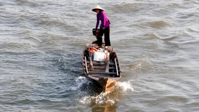Người phụ nữ đi thuyền đến chợ nổi Cái Bè, Việt Nam