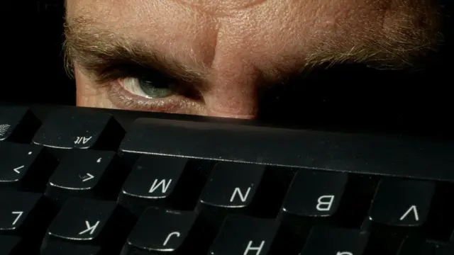 පරිගණක යතුරුපුවරුවකට ඉහළින් ඇස යොමා සිටින අයුරු