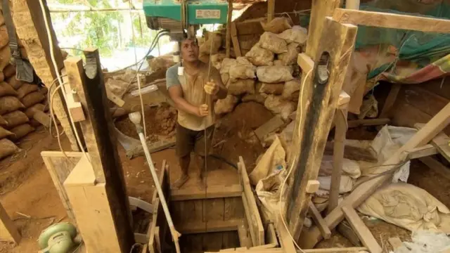 Seorang penambang menarik dua karung tanah dari lubang sedalam 12 meter di pertambangan emas ilegal di Bowone, Sangihe.