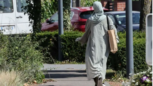 A woman wearing an abaya dress walks through the streets of Lille, northern France, on August 28, 2023
