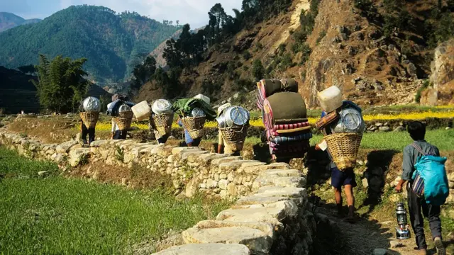 Sherpas caminhando com mochila e carga nas costas