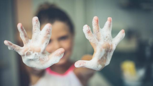 Criança sorri e mostra mãos cheiascomo ganhar casino onlinesabão