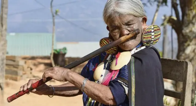 Yaw Shen, yang mendapatkan tato pada usia 15 tahun, menghibur pengunjung dengan memainkan flute hidung, seni yang juga mulai memudar.