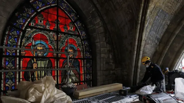 Рабочий около витража внутри Нотра-Дам