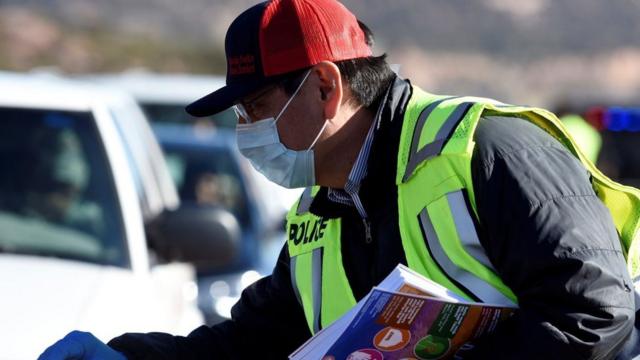 Президент нации навахо раздает брошюры о борьбе с вирусом