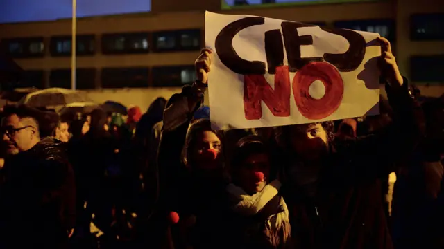 Protestas frente al centro de internamiento de extranjeros en Aluche, Madrid, con un cartel que reza "Cies NO"