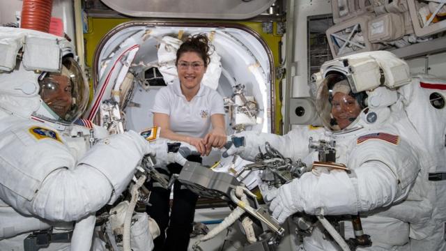 Christina Koch (centre) assists fellow astronauts Nick Hague (left) and Anne McClain in their spacesuits