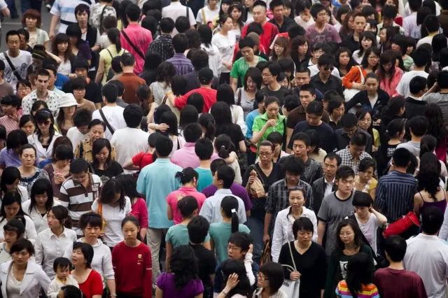 Pedestrians cross a busy intersection in the Xidan shopping area, Beijing.