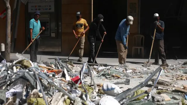 люди расчищают улицы от обломков