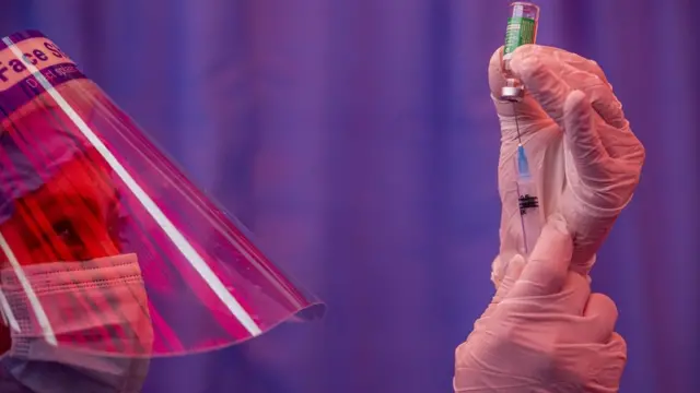 पाटनमा कोभिड खोप लगाइने तयारी गर्दै एक स्वास्थ्यकर्मी