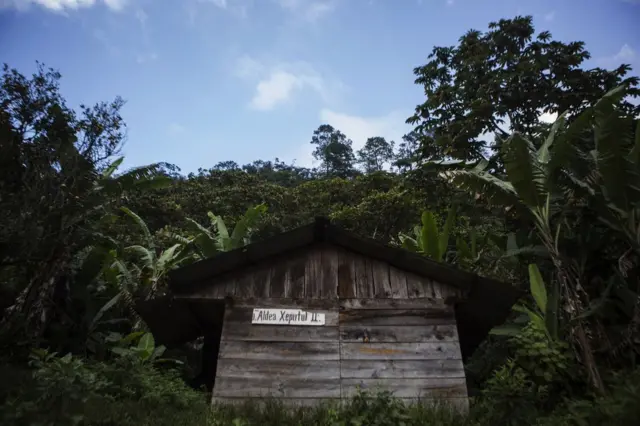 Casa con cartel con el nombre de la aldea en Xeputul II, Guatemala