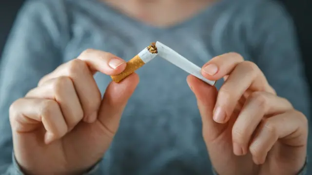 Una mujer rompiendo un cigarrillo