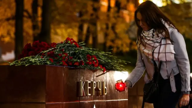 Joven hace una ofrenda por las víctimas del ataque en Crimea.