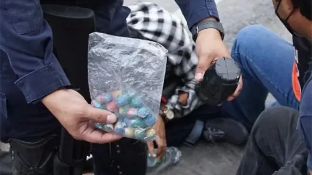 ตำรวจแสดงของกลางที่ยึดได้ หลังจับกุมผู้ชุมนุมที่ดินแดง