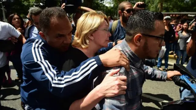 Başsavcı Luisa Ortega, başsavcılığın giriş ve çıkışlarının askerler tarafından kapatılması üzerine ofisine motorsikletle geldi.