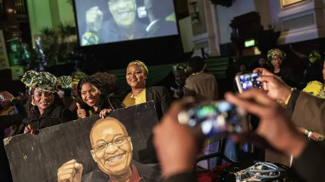 South African governing party African National Congress (ANC) members and supporters pose with a portrait of South African and ANC President Jacob Zuma during a campaign event at the Johannesburg Town Hall in Johannesburg, South Africa - Wednesday 27 July 2016