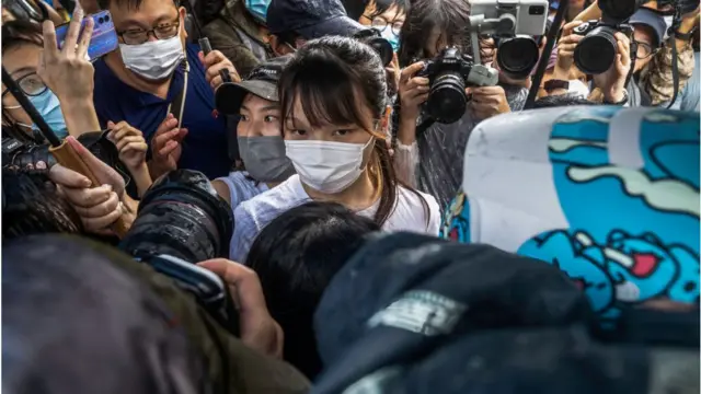Agnes Chow (C) walks through the media pack after being released from the Tai Lam Correctional Institution.