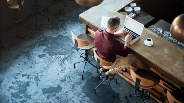 Hombre con computadora en un café