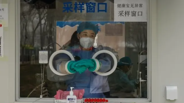 A health worker closes a vial after conducting a COVID-19 test in Beijing, China, 11 April 2022. Shanghai recorded 26,087 new cases making it the fourth consecutive day recording more than 20,000 cases